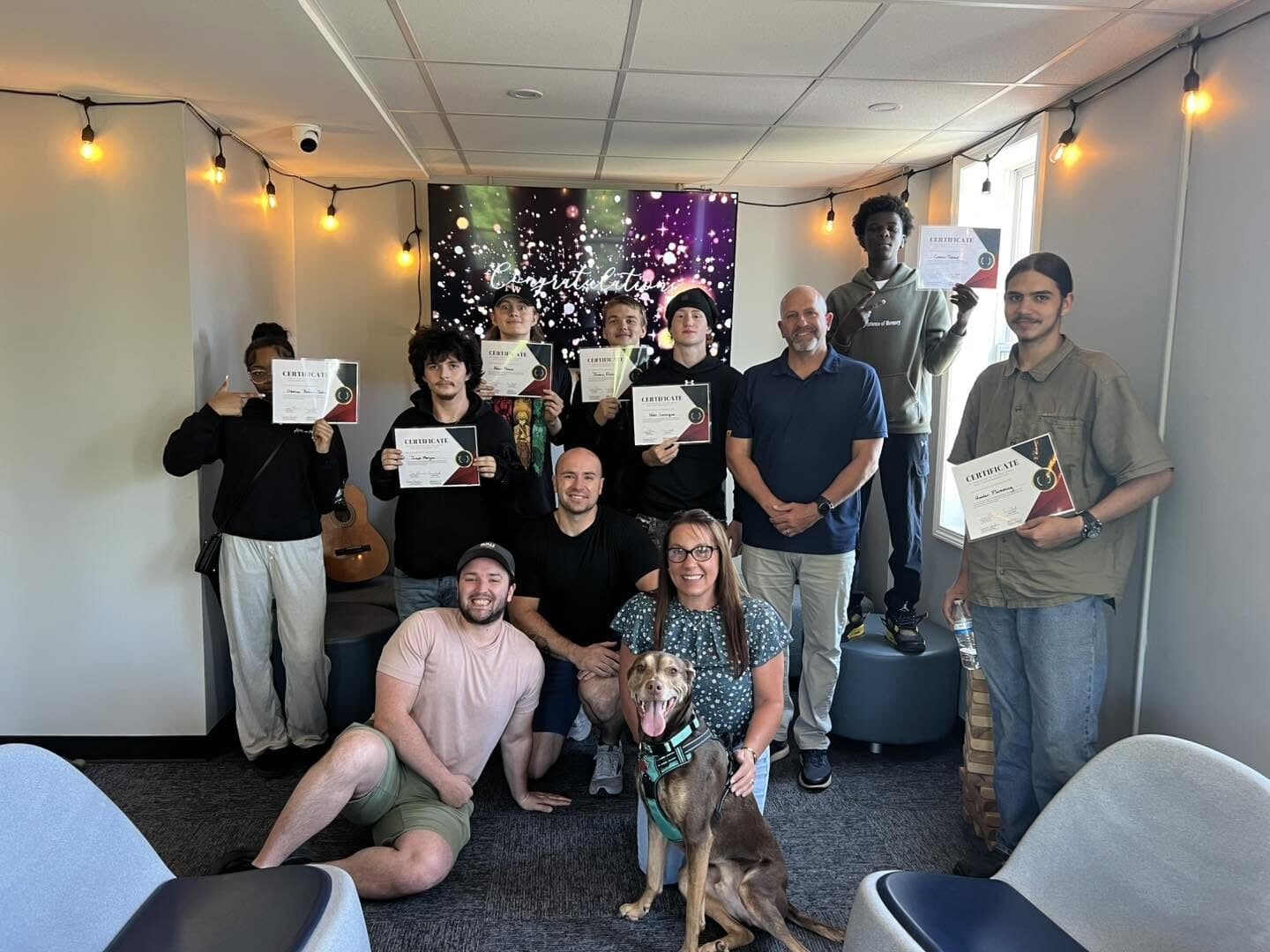 Students and staff holding certificates at a Rise Above celebration