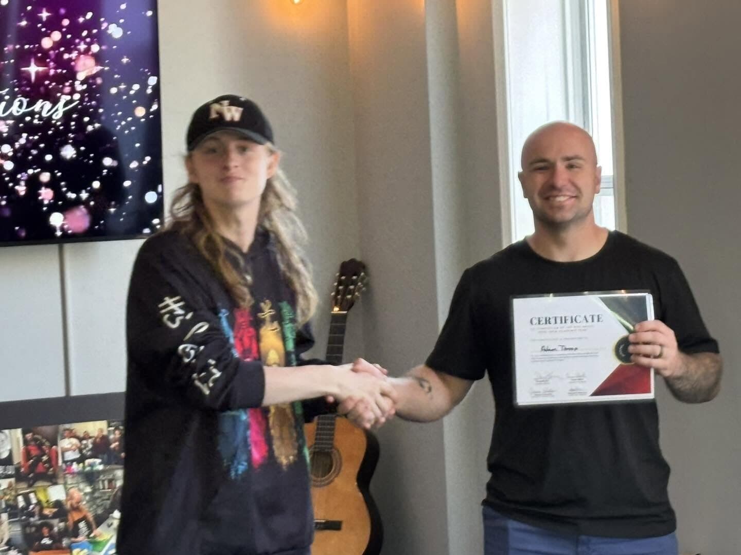 A student receiving a certificate from Rise Above staff