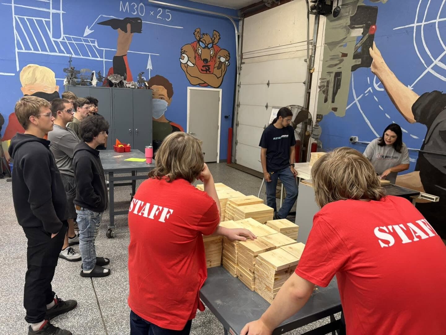 Students building wooden projects with staff in the shop